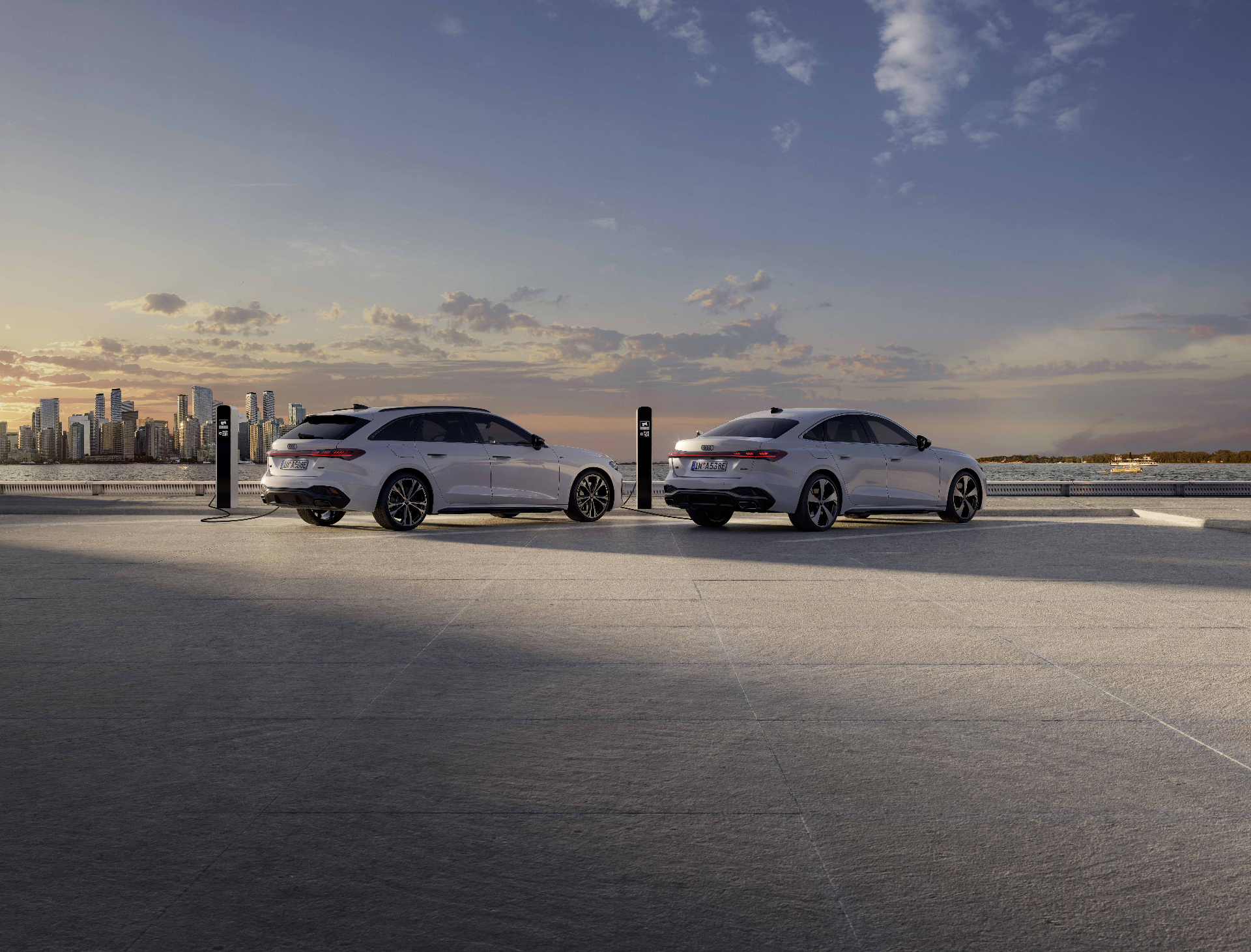 Audi A5 Avant und A5 Limousine laden am Kai vor Skyline – e-Masters-Sonderkonditionen bei atzert:weber